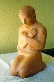 Foto der Terakotta-Plastik "Besinnung": eine menschliche Gestalt kniet in meditierender Haltung mit über den Brust gekreuzten Armen und leicht geneigtem Kopf